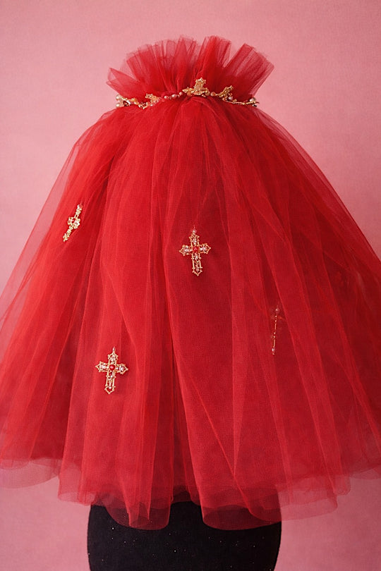 Red Cross My Heart Jeweled Charm Wedding Veil with gold cross charms and jeweled heart details against a blush backdrop