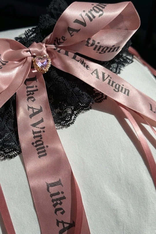 Like A Virgin blush satin bow bridal garter on black lace with crystal heart charm