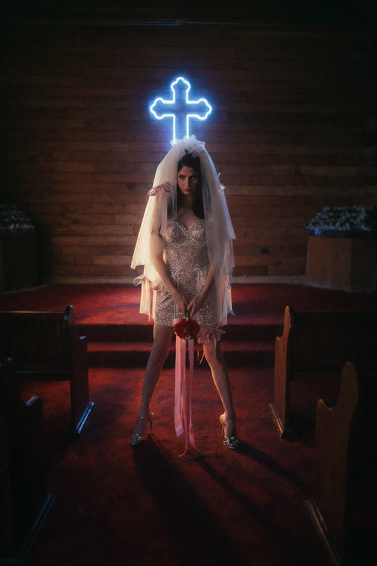 Like A Virgin satin bow wedding veil styled in dramatic chapel with oversized printed ribbon bows and bridal garter