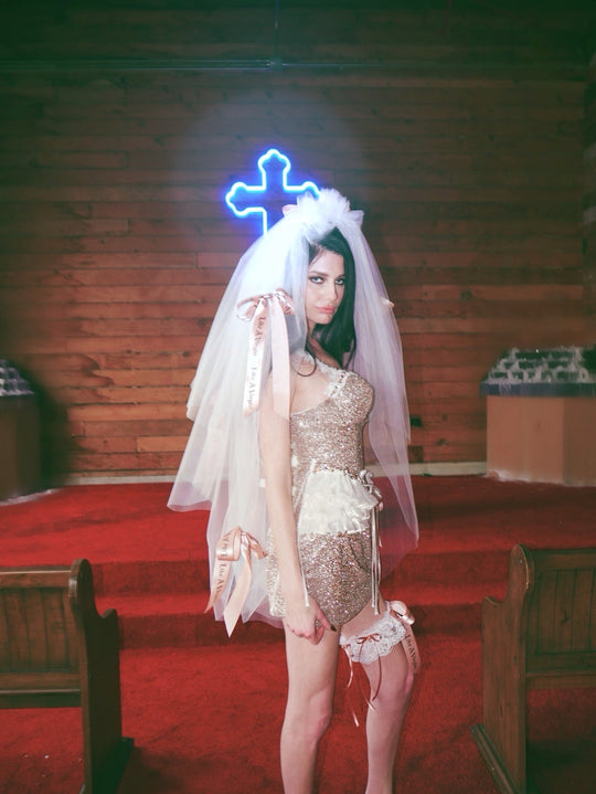 Close view of Like A Virgin satin bow wedding veil with printed ribbon bows and alternative bridal garter