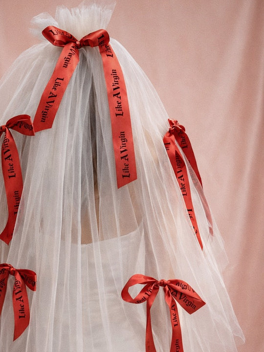 Statement satin bow wedding veil featuring bold red printed ribbons on soft illusion tulle