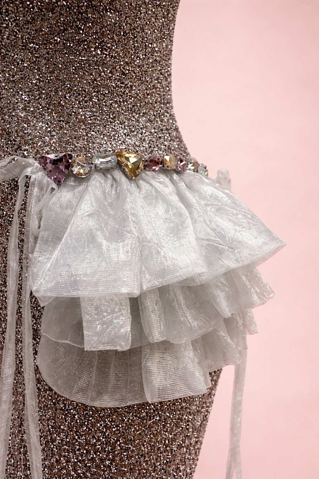 Close-up of ruffle hip detail on glitter mini wedding dress with rhinestone trim.