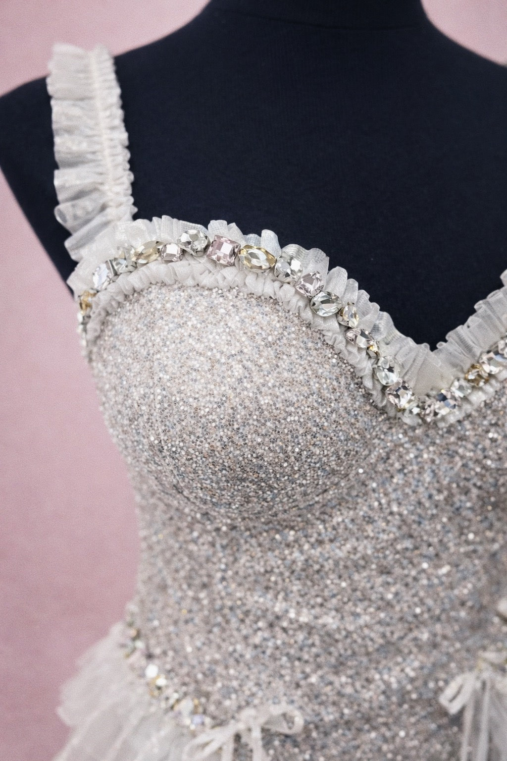 Close-up of rhinestone bustier detail on glitter mini bridal dress.